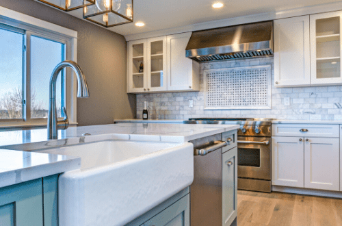 farm style sink in blue kitchen industrial style farmhouse with white counter tops cabinets edison bulb lighting