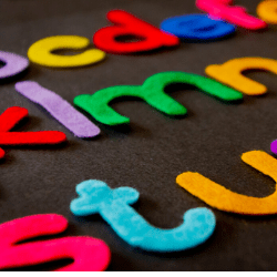 teacher's felt letters cut out on the table. Kids learn to read, write, phonics, letter recognition, with reading applications and apps outside school and classroom